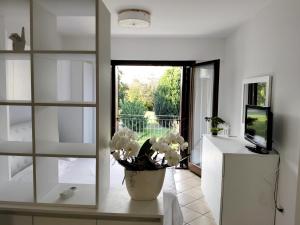 un soggiorno con un vaso di fiori su un tavolo di Alla Stazione - alloggio con parcheggio Spresiano a Spresiano