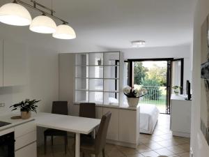 una cucina e una sala da pranzo con un tavolo e un letto di Alla Stazione - alloggio con parcheggio Spresiano a Spresiano Altre 3 foto