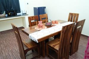una mesa de comedor con sillas y una mesa de madera con en Deepam Haven Inn, en Gūduvāncheri