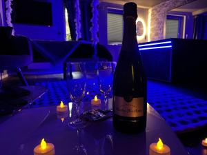 una botella de vino sentada en una mesa con velas en Aux 67 nuances - Spa, en Châtenois