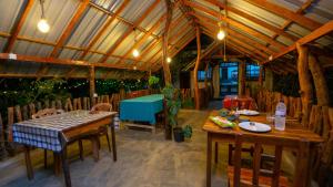 Un comedor con mesas y sillas de madera. en Woodsy Villa, en Sigiriya