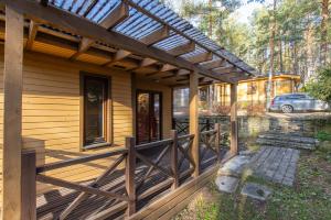 a wooden house with a pergola on the porch at Gauja forest retreat in Gauja