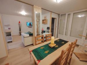 a room with a dining table and a living room at Location MarjoRI - T2 Le Roselin in Le Lauzet-Ubaye