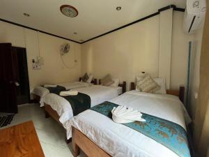 una habitación con dos camas en una habitación en Janh Ya Phone Guesthouse, en Pakbeng