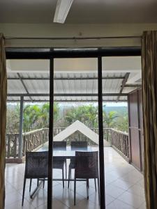 a dining room with a table and chairs on a balcony at Cloud Green Resort in Mahabaleshwar