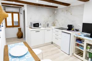a kitchen with white cabinets and a microwave at La Scogliera in Alghero