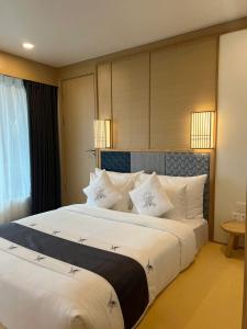 ein Schlafzimmer mit einem großen Bett und weißen Kissen in der Unterkunft Lynntimes Thanh Thủy Wellness Hotel & Resort in La Phu