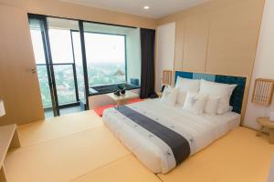 ein Schlafzimmer mit einem großen Bett mit einem großen Fenster in der Unterkunft Lynntimes Thanh Thủy Wellness Hotel & Resort in La Phu