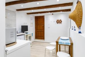 a kitchen with white walls and a wooden door at La Scogliera in Alghero