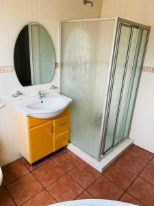 ein Badezimmer mit Waschbecken und Dusche in der Unterkunft Pelistay in Sundowner in Boskruin