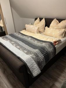 a bed with a black and white blanket and pillows at FeWo Papenburg im OG - Nähe City in Papenburg