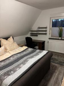a bedroom with a bed and a desk and a window at FeWo Papenburg im OG - Nähe City in Papenburg +11 photos