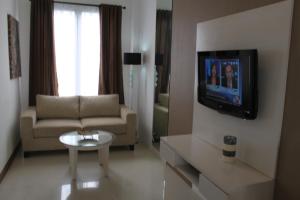 a living room with a couch and a tv at Umalas Apartment in Seminyak