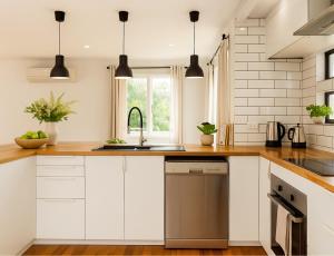 a kitchen with white cabinets and a sink at Patricks Road Ferny Hills in Ferny Hills