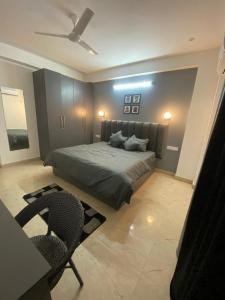 a bedroom with a bed and a chair in it at Rusha Stays in Gumgaon