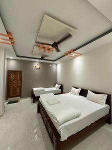 a bedroom with two beds and a ceiling fan at shankar guest house in Hampi
