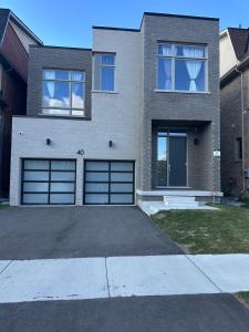 une maison avec deux portes de garage et une allée dans l'établissement Modern 2-Bedroom Apartment in Luxury Home with Gym, à Colline De Richmond