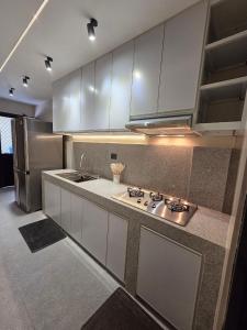 a kitchen with white cabinets and a stainless steel refrigerator at C Urban Villas - Modern Luxury Home in Pampanga in Dau