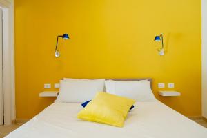 a bed with a yellow wall and two lights on it at Castellinaria Country Resort in Castellana Grotte +60 photos