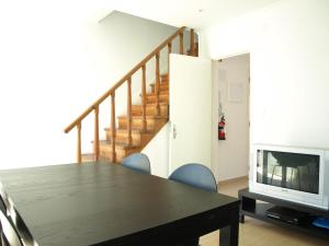 a dining room with a table and a television at Caparica Beach House in Costa da Caparica