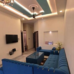 a living room with a blue couch and a tv at Aditi Premium Homestay GF in Jabalpur +12 photos