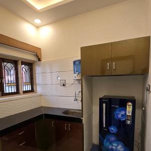 a kitchen with a refrigerator freezer next to a counter at Aditi Premium Homestay GF in Jabalpur