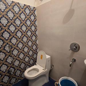 a small bathroom with a toilet and a shower at Aditi Premium Homestay GF in Jabalpur