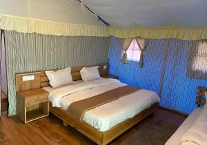 Un dormitorio con una cama grande con paredes azules. en Baromas Resort and Camping, en Kailāna