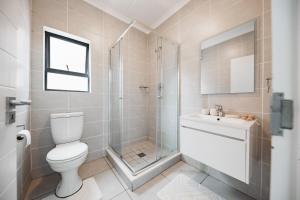 a bathroom with a shower and a toilet and a sink at Casa de Lior!- Luxury apartment in Sandton +20 photos