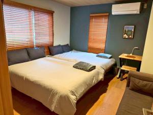 a bedroom with a bed and a couch at Relaxing箱根彫刻の森ーサウナ付き一棟貸しの宿 in Hakone