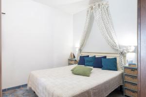 a bedroom with a bed with blue and green pillows at Mini Appartemento vista mozzafiato in Santa Maria Navarrese