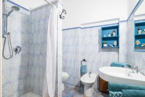 a blue tiled bathroom with a sink and a toilet at Mini Appartemento vista mozzafiato in Santa Maria Navarrese +20 photos