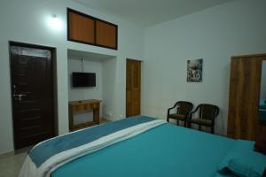 a bedroom with a blue bed and two chairs at Prashanthi Nature View - Luxury 2Bhk Villa in Udupi +16 photos