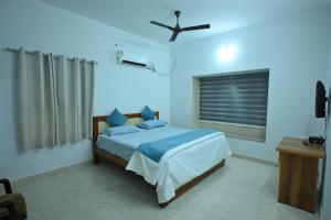a bedroom with a bed and a ceiling fan at Prashanthi Nature View - Luxury 2Bhk Villa in Udupi