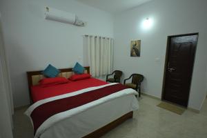a bedroom with a bed with red and blue pillows at Prashanthi Nature View - Luxury 2Bhk Villa in Udupi