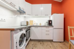 a kitchen with a washing machine and a refrigerator at Gauja forest retreat in Gauja