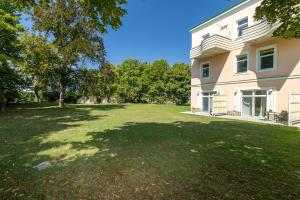 a large yard in front of a house at Giardino Airport Apartment with garden in Schwechat +6 photos