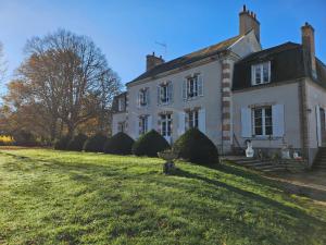ein großes weißes Haus mit einem Rasenplatz in der Unterkunft domaine de la chapelliere 32 pers in Crouy-sur-Cosson