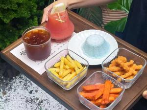 a wooden table with four containers of food and a drink at Tuji Lane and Fanghe Homestay (West Street Kaiyuan Temple Branch) in Quanzhou