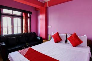 a bedroom with a bed with red pillows on it at Hotel O Chewang Homestay in Darjeeling +21 photos