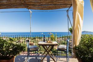 a table and chairs on a patio with a view of the ocean at Mini Appartemento vista mozzafiato in Santa Maria Navarrese