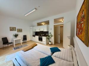 a bedroom with a large bed and a kitchen at Giardino Airport Apartment with garden in Schwechat
