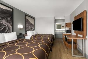 a hotel room with two beds and a desk at Super 8 by Wyndham Fort Bragg in Fort Bragg +98 photos