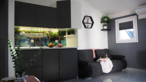 a kitchen with black cabinets and a couch in a room at Apartment Sova or Deluxe room 33 in Bled