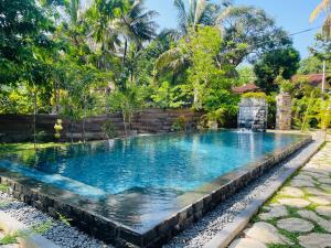 a swimming pool with a waterfall in a garden at Villa Climax in Ahangama