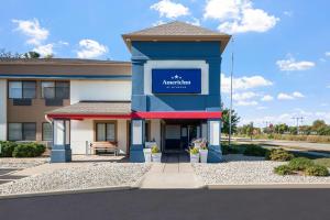 un edificio con una señal azul en la parte delantera en AmericInn by Wyndham Beloit, en Beloit