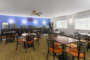 ein Esszimmer mit Tischen und Stühlen und einer Bar in der Unterkunft Baymont by Wyndham Piqua in Piqua