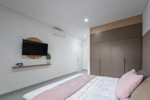 a bedroom with a bed and a tv on the wall at Cove Nawaprita in Jakarta