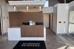 a lobby with a reception desk in a building at Wingate by Wyndham Geneva at SPIRE Academy in Geneva