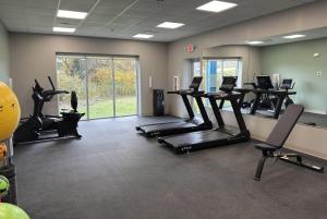 a gym with treadmills and ellipticals in a room at Wingate by Wyndham Geneva at SPIRE Academy in Geneva